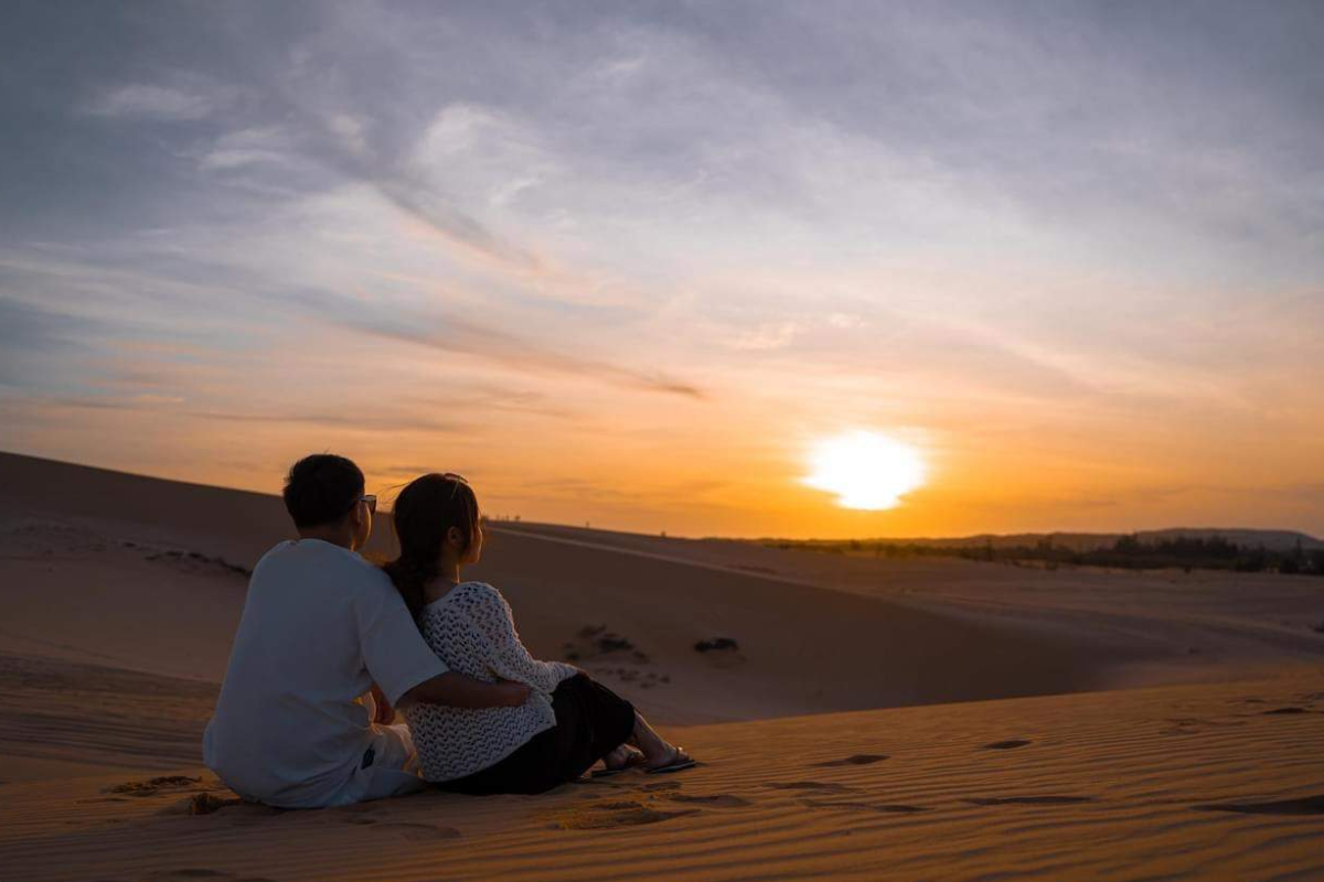 Tourists exploring the Red Sand Dunes near Mui Ne under a bright blue sky